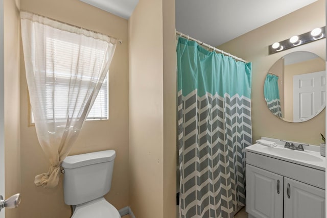 bathroom with walk in shower, vanity, and toilet