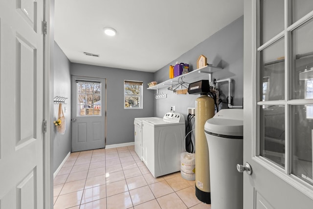 laundry area with washer and dryer and light tile patterned floors