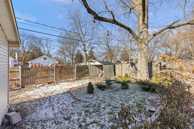 yard layered in snow featuring a storage shed