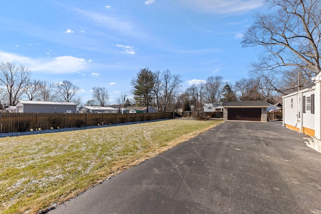 view of yard featuring a garage and an outbuilding