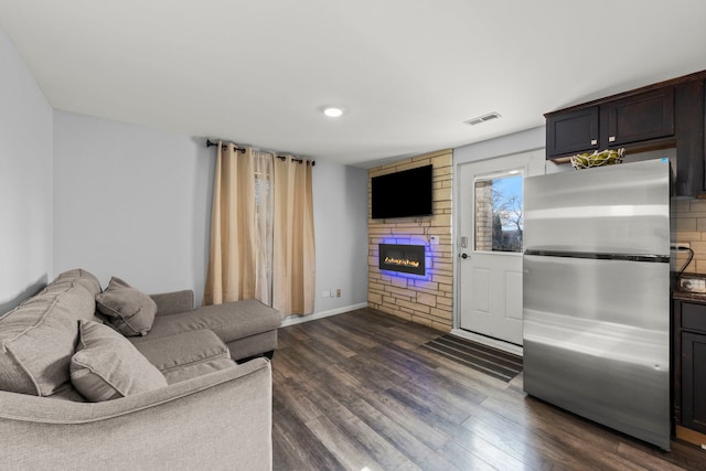 living room with a fireplace and dark wood-type flooring