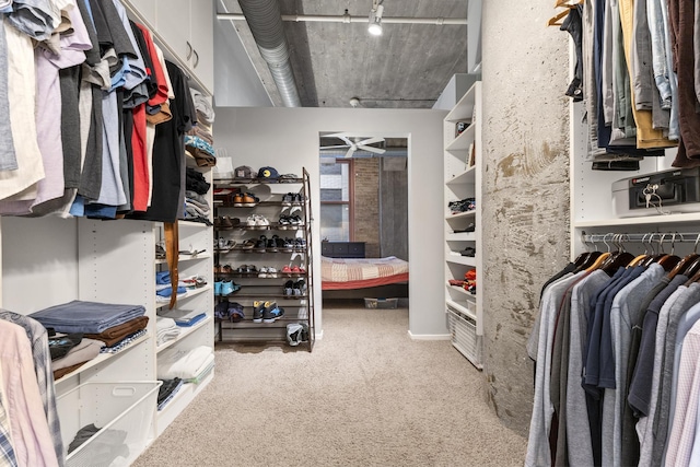 walk in closet featuring light carpet