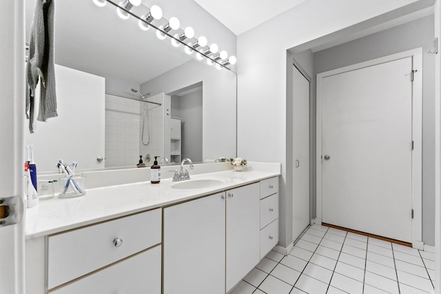 bathroom featuring tile patterned flooring, vanity, and tiled shower