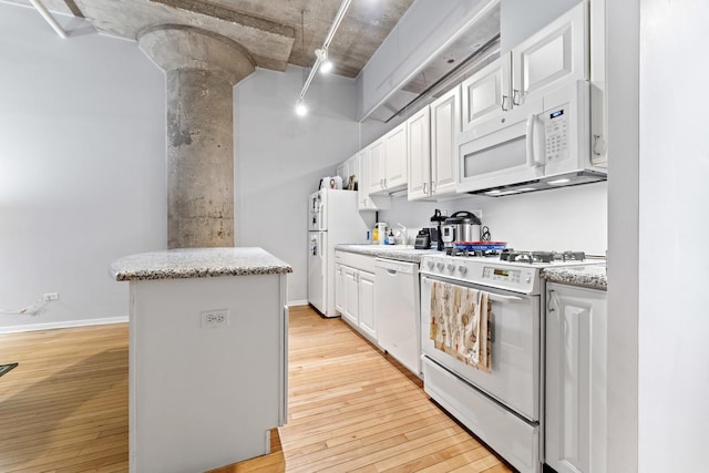 kitchen with white appliances, light wood-type flooring, ornate columns, a kitchen island, and white cabinetry