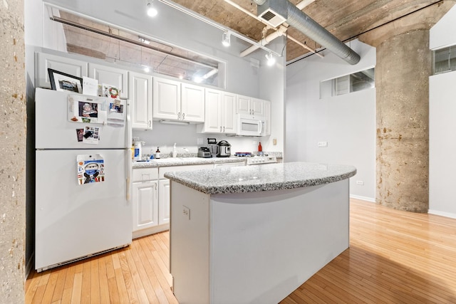 kitchen with a center island, white cabinetry, white appliances, and light hardwood / wood-style flooring