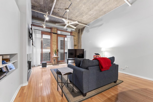 living room with ceiling fan and light hardwood / wood-style flooring