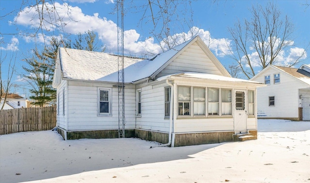 snow covered property featuring a sunroom