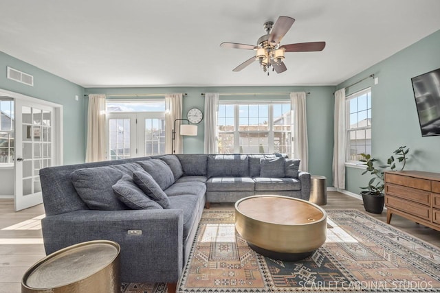 living room with french doors, ceiling fan, and light hardwood / wood-style flooring