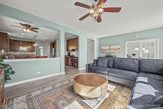 living room featuring hardwood / wood-style flooring and ceiling fan