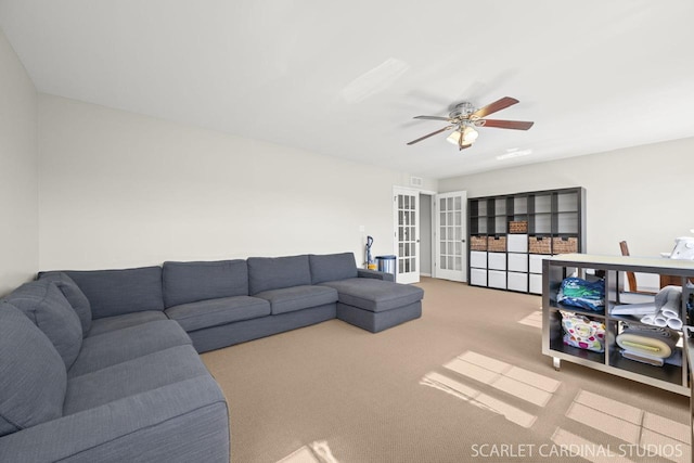 carpeted living room featuring french doors and ceiling fan