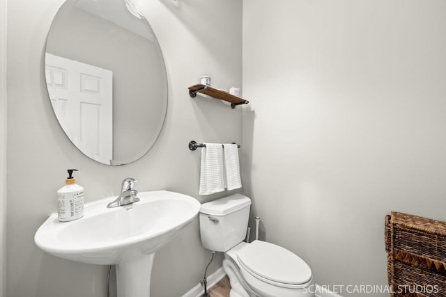 bathroom with wood-type flooring, toilet, and sink