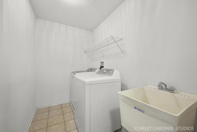 clothes washing area featuring separate washer and dryer, sink, and light tile patterned floors