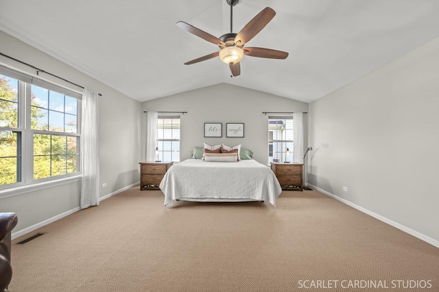 carpeted bedroom with multiple windows, vaulted ceiling, and ceiling fan