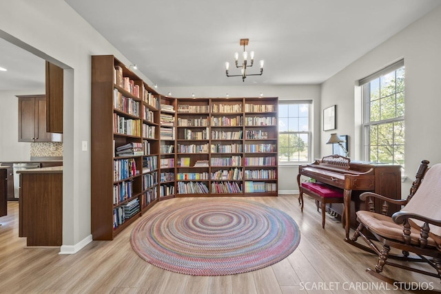 living area with an inviting chandelier and light hardwood / wood-style flooring