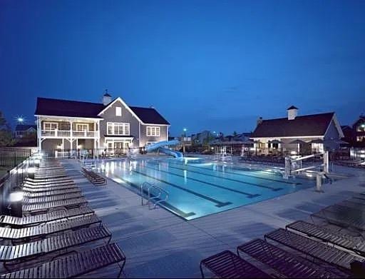 pool at night featuring a patio and a water slide