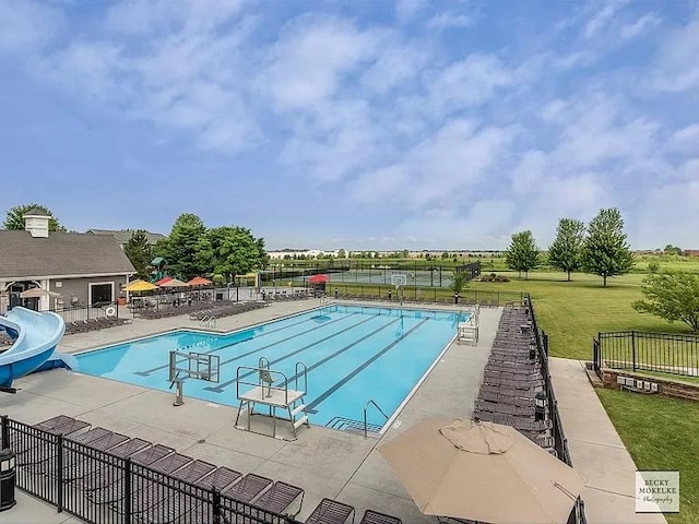 view of swimming pool featuring a yard, a patio, and a water slide