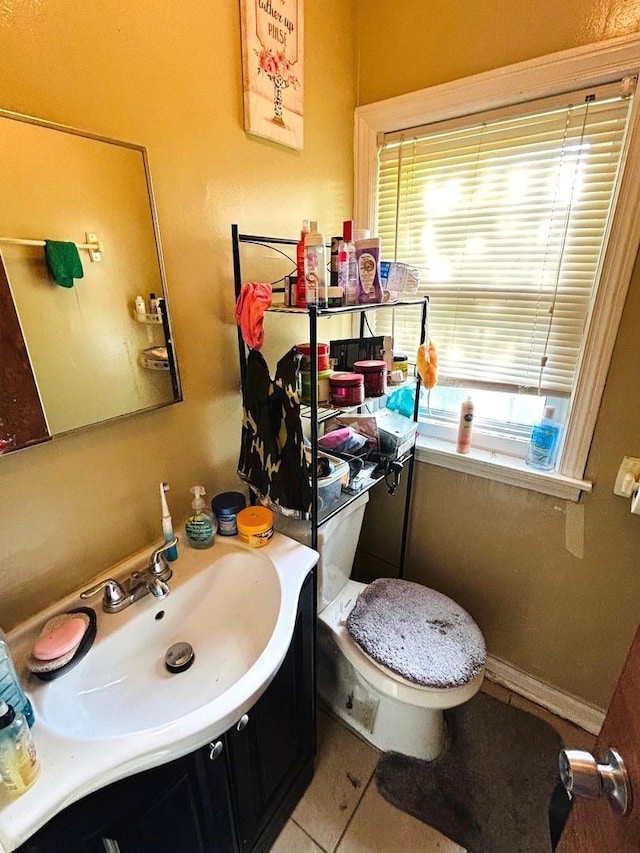 bathroom featuring tile patterned flooring, vanity, toilet, and a wealth of natural light