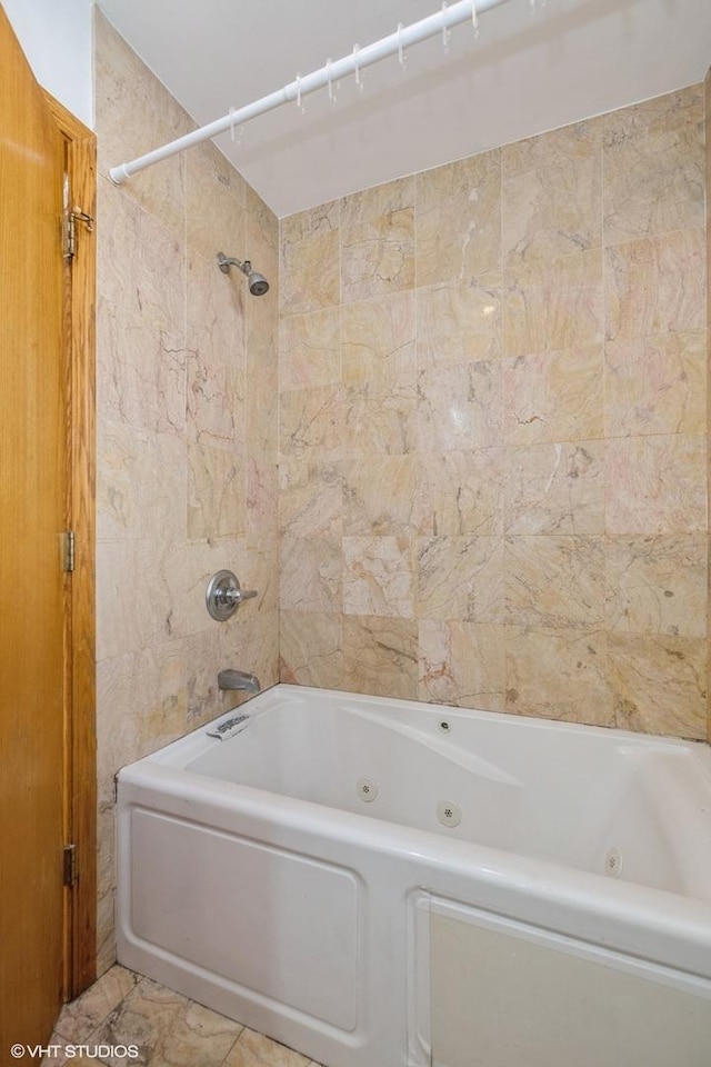 bathroom featuring tile patterned floors and tiled shower / bath