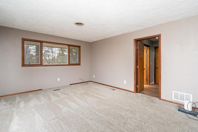 carpeted spare room featuring a textured ceiling