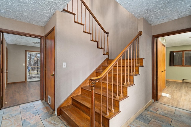 stairway featuring hardwood / wood-style flooring and a textured ceiling