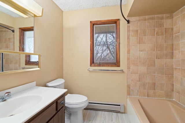 full bathroom with toilet, tiled shower / bath, baseboard heating, vanity, and hardwood / wood-style floors