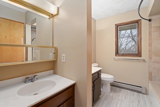 bathroom with baseboard heating, vanity, wood-type flooring, a textured ceiling, and toilet