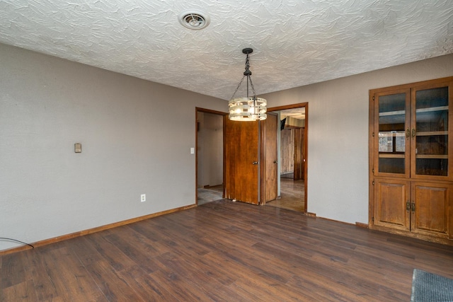 unfurnished dining area with dark hardwood / wood-style flooring and a textured ceiling