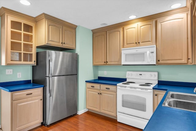 kitchen with wood-type flooring, white appliances, and sink