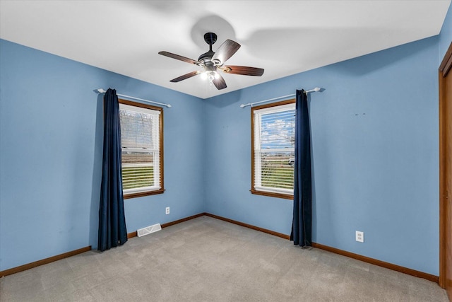 empty room featuring ceiling fan and light carpet