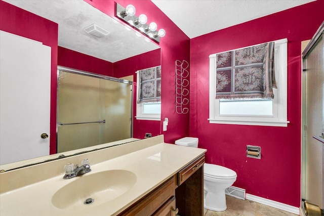 bathroom with plenty of natural light, a textured ceiling, and toilet