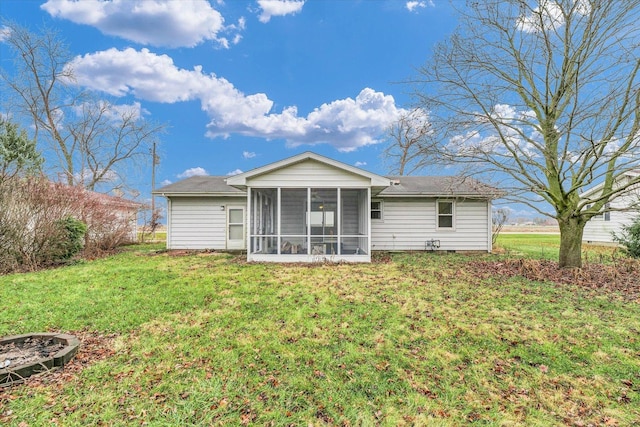 rear view of house with a sunroom and a yard