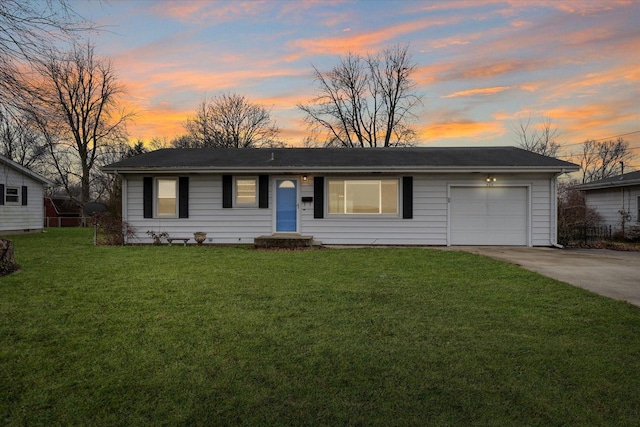 ranch-style home featuring a garage and a yard