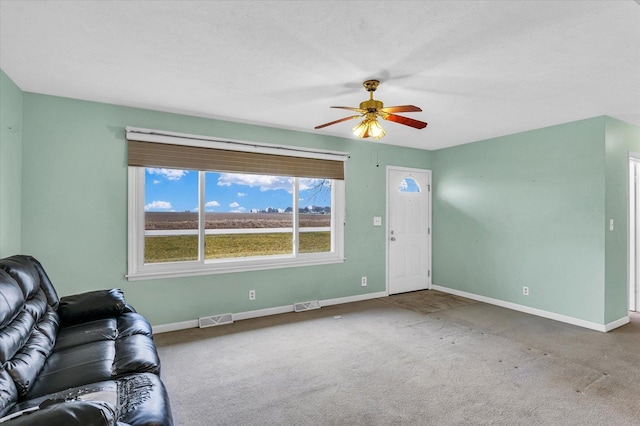 unfurnished living room featuring carpet flooring and ceiling fan