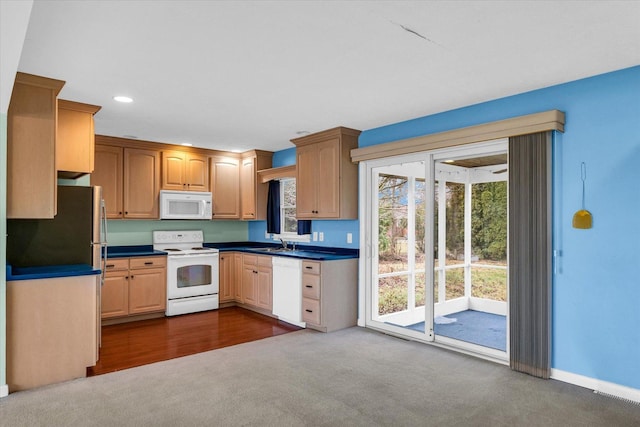 kitchen featuring dark colored carpet, white appliances, and sink