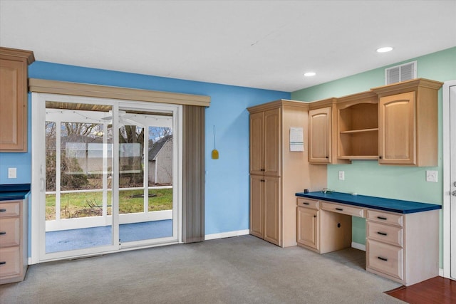 kitchen with a healthy amount of sunlight, light carpet, and light brown cabinetry