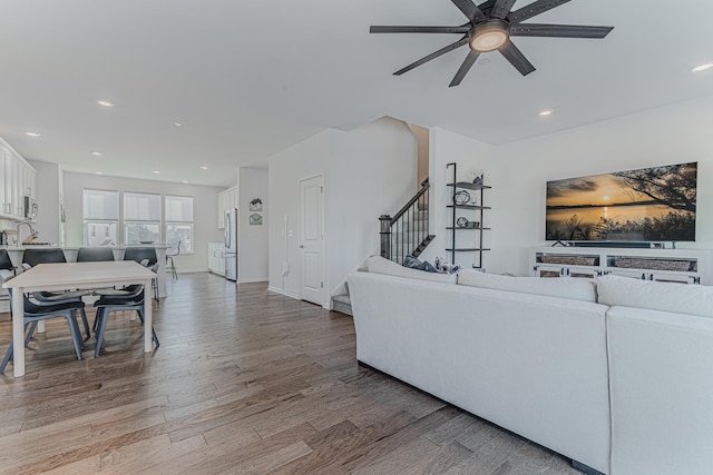 living room featuring hardwood / wood-style flooring, ceiling fan, and sink