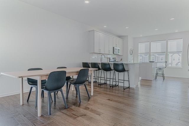 dining space with sink and light hardwood / wood-style floors