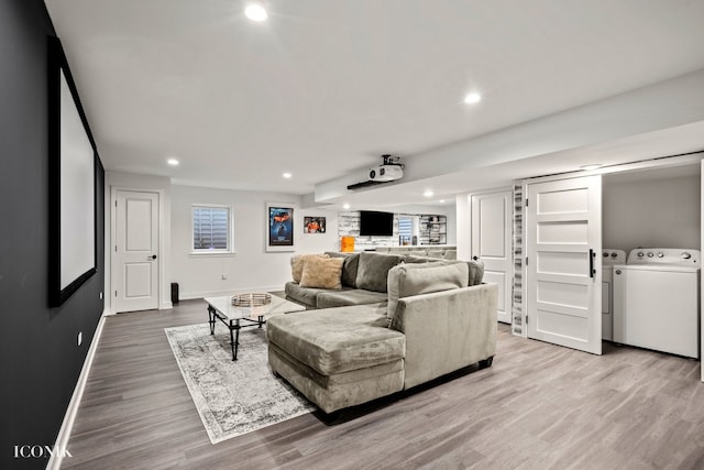 living room with independent washer and dryer and light wood-type flooring