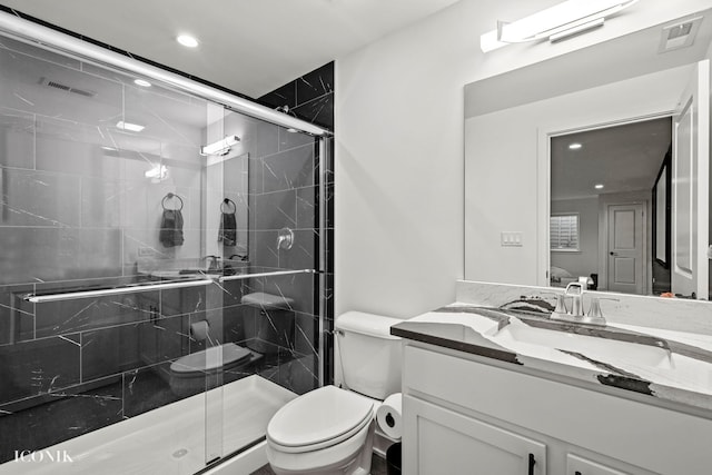 bathroom featuring an enclosed shower, vanity, and toilet