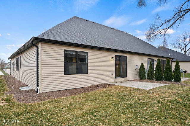 rear view of property featuring a lawn and a patio area