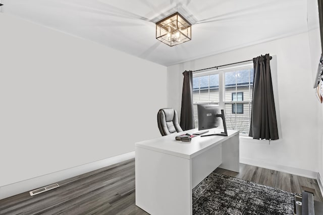 home office featuring dark hardwood / wood-style floors and an inviting chandelier