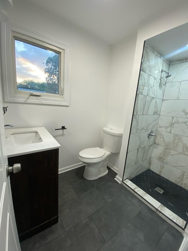 bathroom featuring vanity, toilet, and tiled shower