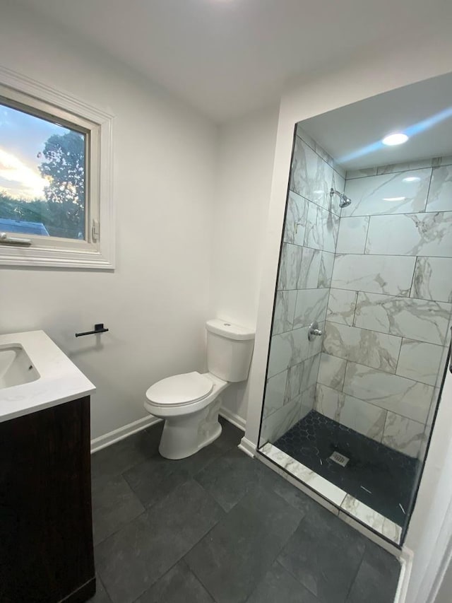 bathroom with vanity, toilet, and a tile shower