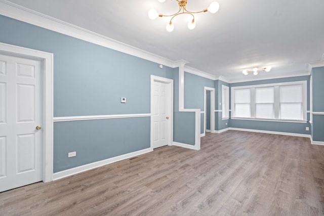 unfurnished living room featuring a notable chandelier, crown molding, and light hardwood / wood-style flooring