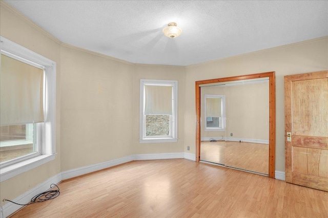 unfurnished bedroom featuring a textured ceiling, light hardwood / wood-style floors, and a closet