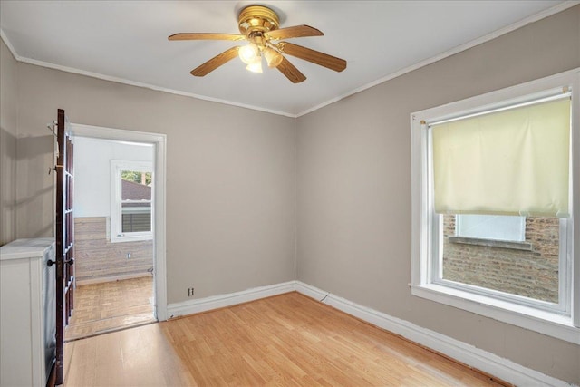 empty room with ceiling fan, light hardwood / wood-style floors, and crown molding