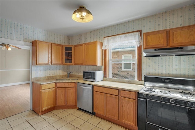 kitchen with ceiling fan, sink, light tile patterned floors, and stainless steel appliances