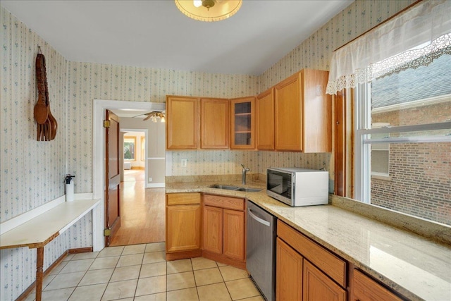 kitchen with dishwasher, sink, light tile patterned floors, and a healthy amount of sunlight