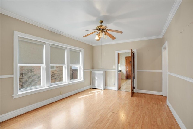 empty room featuring ceiling fan, ornamental molding, and light hardwood / wood-style flooring