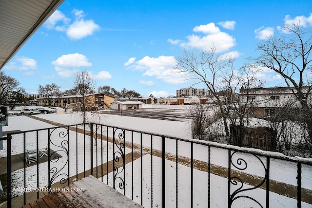 view of snow covered back of property